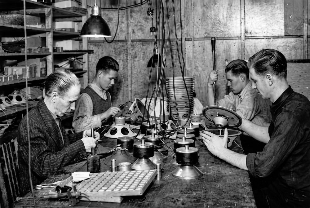 Archive photograph: craftsmen assembling loudspeaker drivers and magnets at the bench