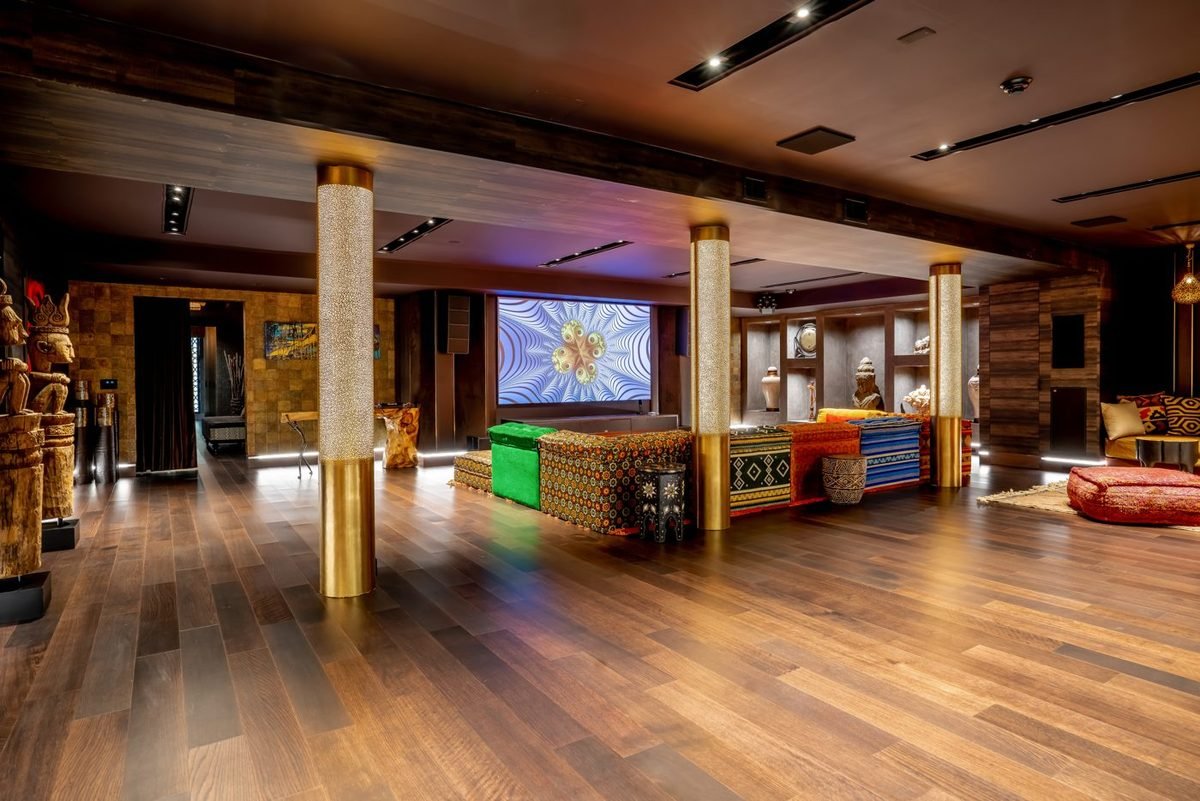 Lounge-style media room with gold columns and a large screen