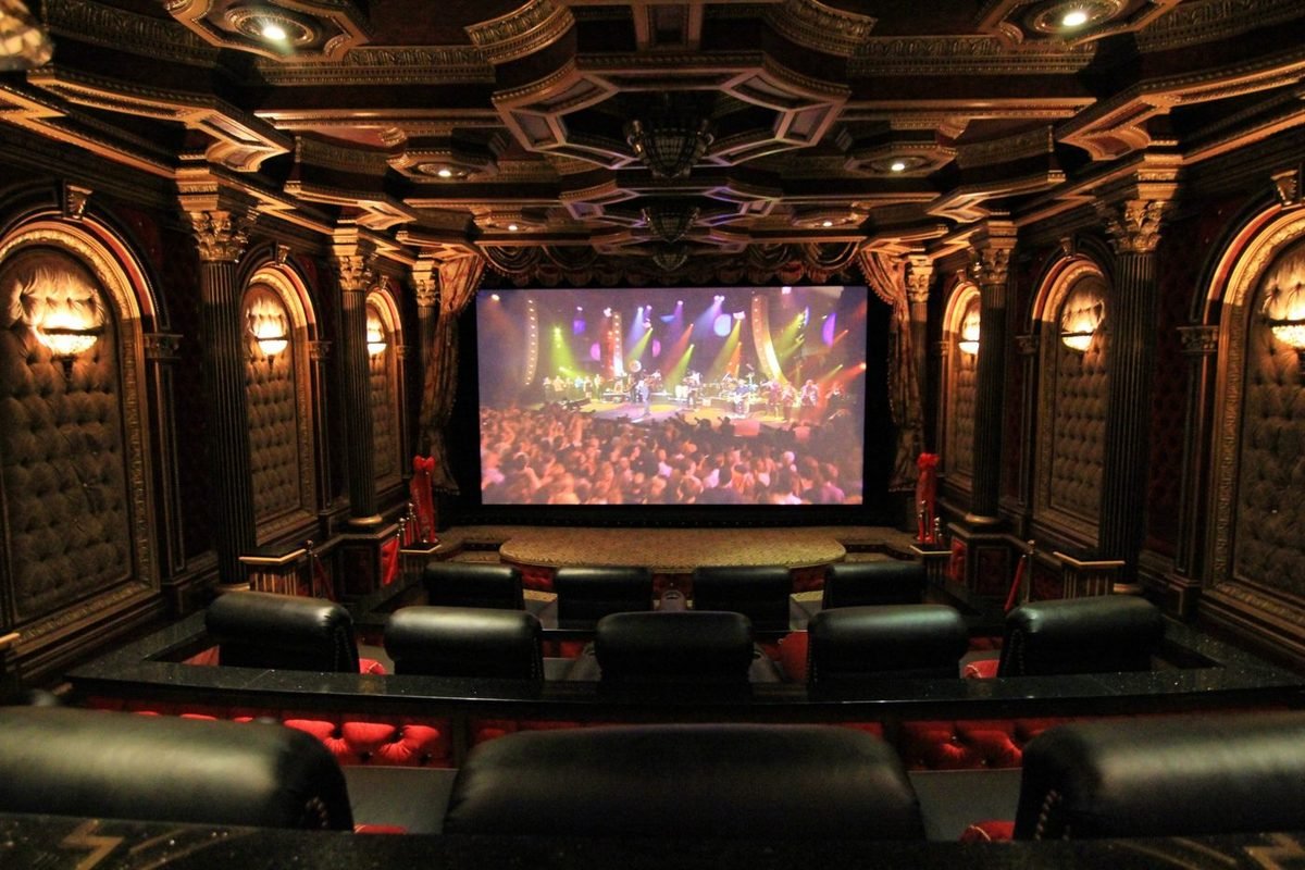Grand theater with arched tufted panels and a concert on screen